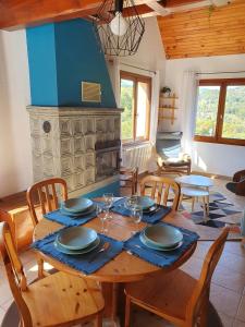 comedor con mesa, sillas y chimenea en Le Chant du Loriot, en Labaroche