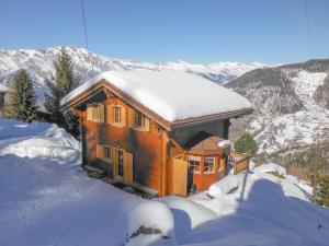 a small wooden house covered in snow in the mountains at Chalet les Bubus in La Tzoumaz