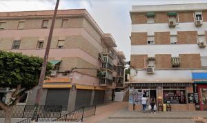 duas pessoas a andar numa rua em frente a edifícios em Apartamento renovado y tranquilo, ideal familias - los mejores accesos em Málaga