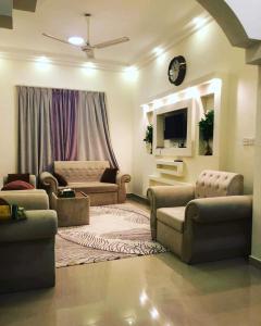 sala de estar con 2 sofás y TV en TWO BEDROOM FULLY FURNISHED APARTMENTS, en Salalah