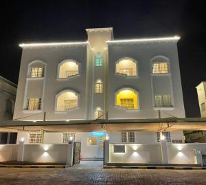 a large white building with windows at night at TWO BEDROOM FULLY FURNISHED APARTMENTS in Salalah
