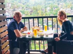 Un uomo e una donna seduti a un tavolo con del cibo di Quick Stop Inn a Kandy