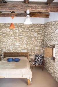 a bedroom with a bed and a stone wall at Il giardino dei mandorli Agriturismo in Alatri +18 photos