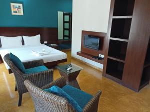 Habitación de hotel con cama, TV y sillas en TRANSTREE at Brookfields, en Bangalore