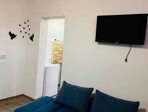 sala de estar con sofá azul y TV de pantalla plana en Hotel Sunny, en Akhaltsikhe