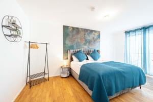 a bedroom with a large bed with a blue blanket at Lit Living: Luxus - Box Spring - Parking - Terrace in Ludwigshafen am Rhein