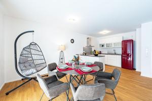 a living room with a table and chairs and a kitchen at Lit Living: Luxus - Box Spring - Parking - Terrace in Ludwigshafen am Rhein