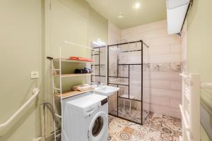 a bathroom with a washing machine and a shower at Gîte de la Presqu'île de Lézardrieux, adapté PMR in Lézardrieux