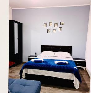 ein Schlafzimmer mit einem großen Bett mit einer blauen Decke in der Unterkunft Hotel Sunny in Achalziche
