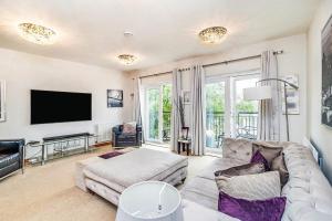 uma sala de estar com um sofá e uma televisão de ecrã plano em Executive Lakeside 4 Bed Townhouse em Simpson