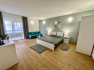 ein Schlafzimmer mit einem Bett und einem blauen Sofa in der Unterkunft Apartament Novara 1 in Craiova