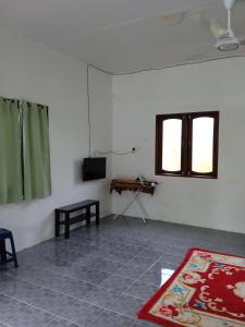 een woonkamer met een televisie en een tapijt bij Homestay Idaman di Kuala Terengganu dengan 2 Bilik Aircond - Harga utk 1 rumah in Kuala Terengganu