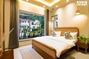 a bedroom with a bed and a large window at StayVista at Villa Vaari with Pvt Pool & Gazebo in Dehradun +25 photos