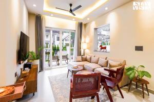a living room with a couch and a table at StayVista at Villa Vaari with Pvt Pool & Gazebo in Dehradun