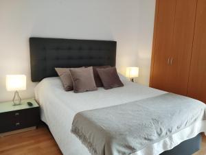 a bedroom with a large bed with two lamps at Apartment Airport Barcelona Premium in Viladecáns