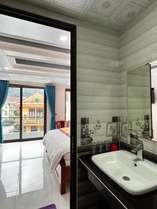 La salle de bains est pourvue d'un lavabo, d'un lit et d'un miroir. dans l'établissement Quoc Tuan Hotel Sapa, à Sa Pa