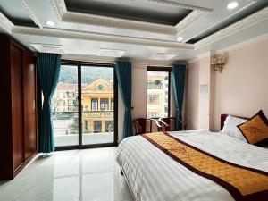 - une chambre avec un lit et une grande fenêtre dans l'établissement Quoc Tuan Hotel Sapa, à Sa Pa