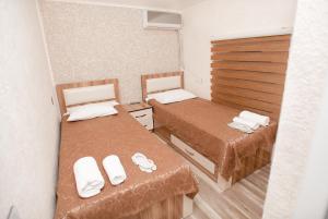 a small room with two beds with towels on them at NM Butik Hotel in Ganja