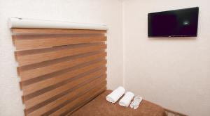 Pokój z drewnianą ścianą i telewizorem z płaskim ekranem w obiekcie NM Butik Hotel w mieście Gandża