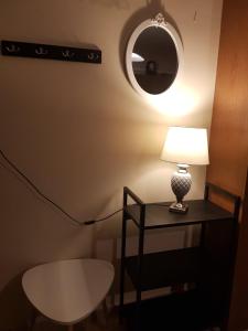 a lamp on a table with a round mirror at The Quiet Corner in Kalamata