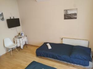 1 dormitorio con 1 cama azul y 1 silla en Ceramika Bolesławiec - Pensjonat, en Bolesławiec