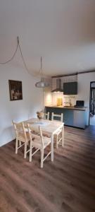 a white table and chairs in a room with a kitchen at NOOK studio apartman Lokve in Lokve
