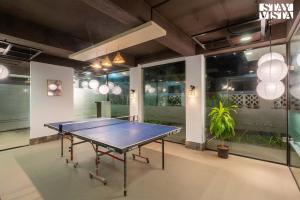 a ping pong table in the middle of a room at River Song by VEO - Part of StayVista in Lonavala
