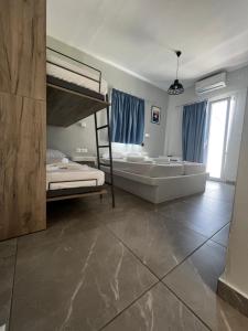 a bedroom with two bunk beds and a tub at Princess Sissy in Ios Chora