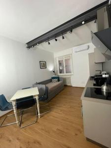 a living room with a couch and a table and a kitchen at Cairoli Apartment in Ravenna