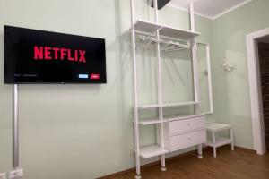 a tv hanging on a wall next to a white dresser at Cairoli Apartment in Ravenna