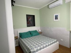 a bedroom with a bed with green pillows at Cairoli Apartment in Ravenna