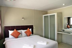een slaapkamer met een groot bed met oranje kussens bij Pacific Residence in Hat Yai