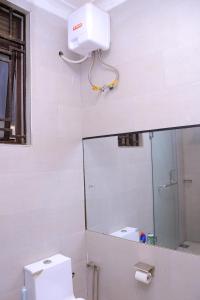 a white bathroom with a mirror and a toilet at Peaceful Home in Kampala +29 photos