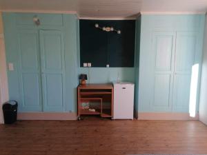 Il comprend une cuisine dotée de murs bleus et d'un réfrigérateur blanc. dans l'établissement Chambre La noyeraie, à Saint-Nicolas-de-la-Grave