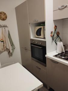a small kitchen with a stove and a microwave at Residenza Mariuccia in Bellaria-Igea Marina