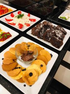 uma mesa coberta com diferentes tipos de alimentos em pratos em Hotel La Bella Soma em Soma