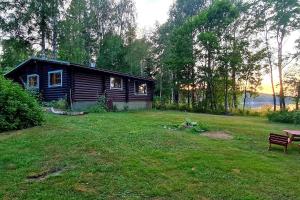 a log cabin in a yard with a picnic table at Cozy Beach Cabin - close to city center in Pargas