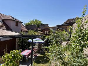 um jardim com uma mesa e um guarda-sol em Le Refuge du Rempart em Dambach-la-Ville
