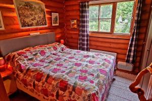 a bedroom with a bed in a log cabin at Cozy Beach Cabin - close to city center in Pargas