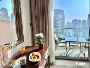 Cette chambre d'hôtel comprend une table avec un bol de fruits et une fenêtre. dans l'établissement Luxury Address Res DubaiMarina Studio1 Frank&Frank, à Dubaï
