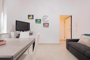 een woonkamer met een bank en een tv bij La casa di Alessia nel centro di Como - Alessiatravelling in Como