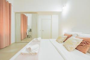 ein weißes Zimmer mit einem Bett und einem Spiegel in der Unterkunft La casa di Alessia nel centro di Como - Alessiatravelling in Como