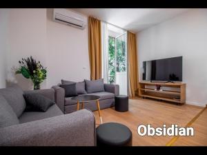 Una sala de estar con un sofá y un televisor de pantalla plana. en Apartments Euphoria East, en Rijeka