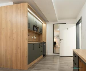 a kitchen with wooden cabinets and a sliding door at Louis Apartments in Rosbach vor der Höhe