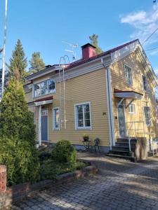 una casa amarilla con una entrada de ladrillo delante de ella en Paritalohuoneisto keskustassa, en Valkeakoski