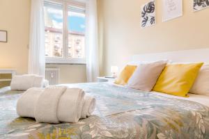 1 dormitorio con 1 cama grande con almohadas amarillas en Vista Mole, Centro a 15 min - Luxury Suites & fast WiFi, en Turín
