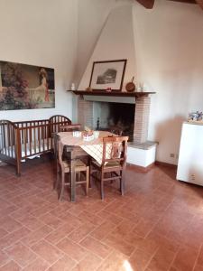 comedor con mesa, sillas y chimenea en La Capretta Country House, en Parrano