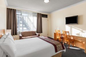 Habitación de hotel con cama y escritorio en Best Western Governor Gipps Motor Inn en Traralgon