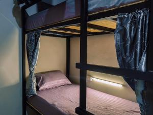 a bedroom with two bunk beds in a room at 107 Hostel (One-O-Seven Hostel) in Kanchanaburi