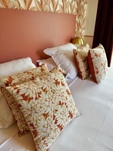 a bedroom with a bed with pillows on it at Hôtel De Londres in Menton